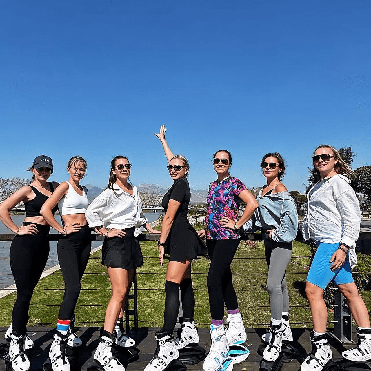 Group of women posing outdoors with a clear blue sky