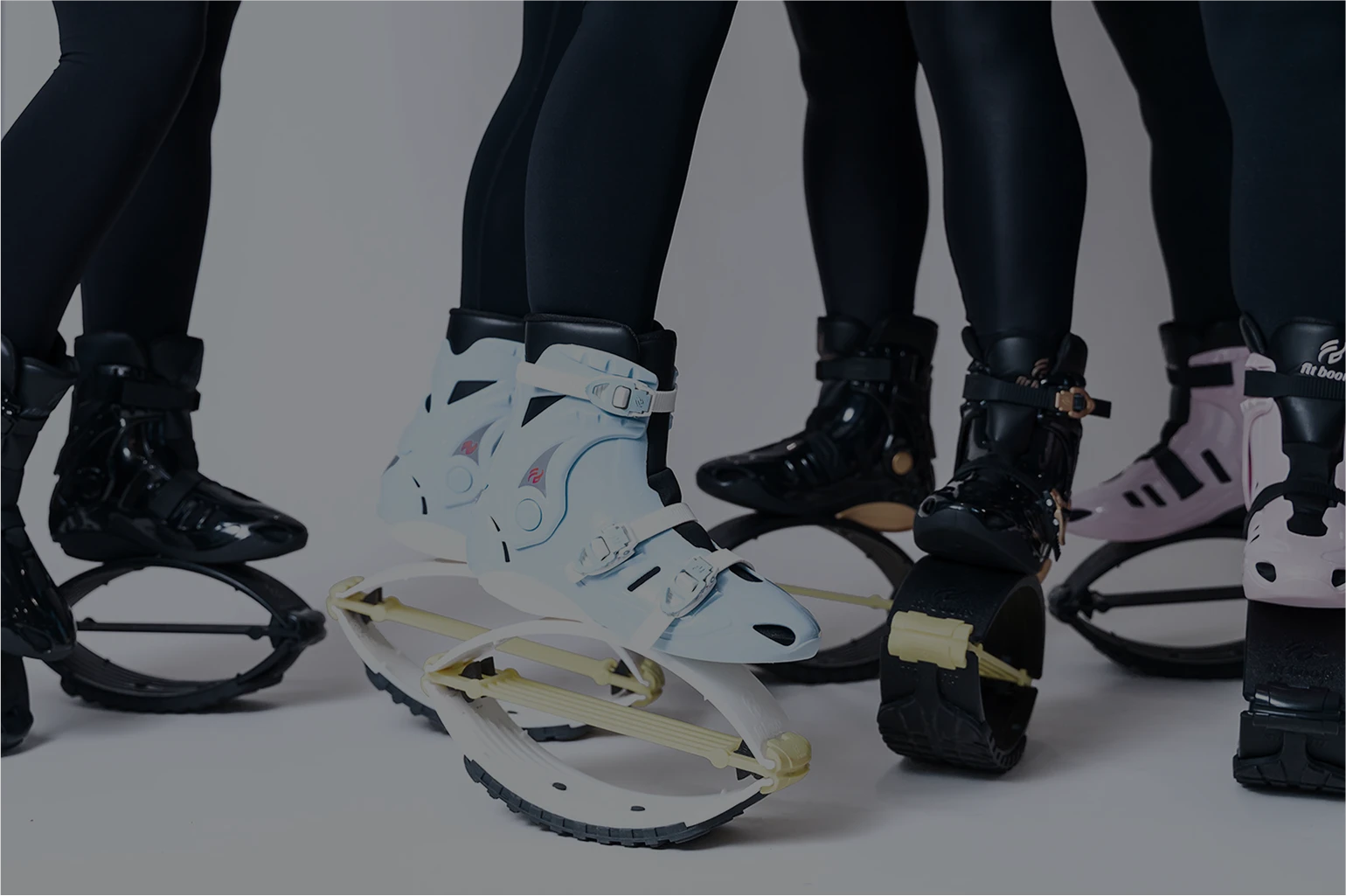 Close-up of feet wearing unique snowshoe-like devices on a plain background