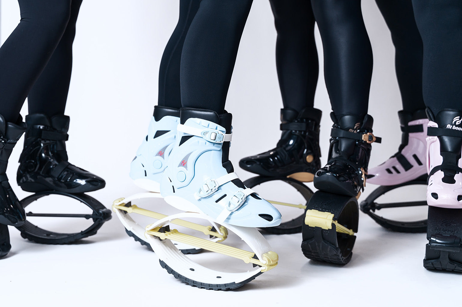 Close-up of feet wearing various types of shoes on a white background