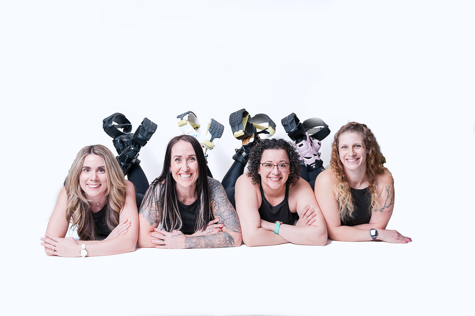 Four women posing with various hats on a white background