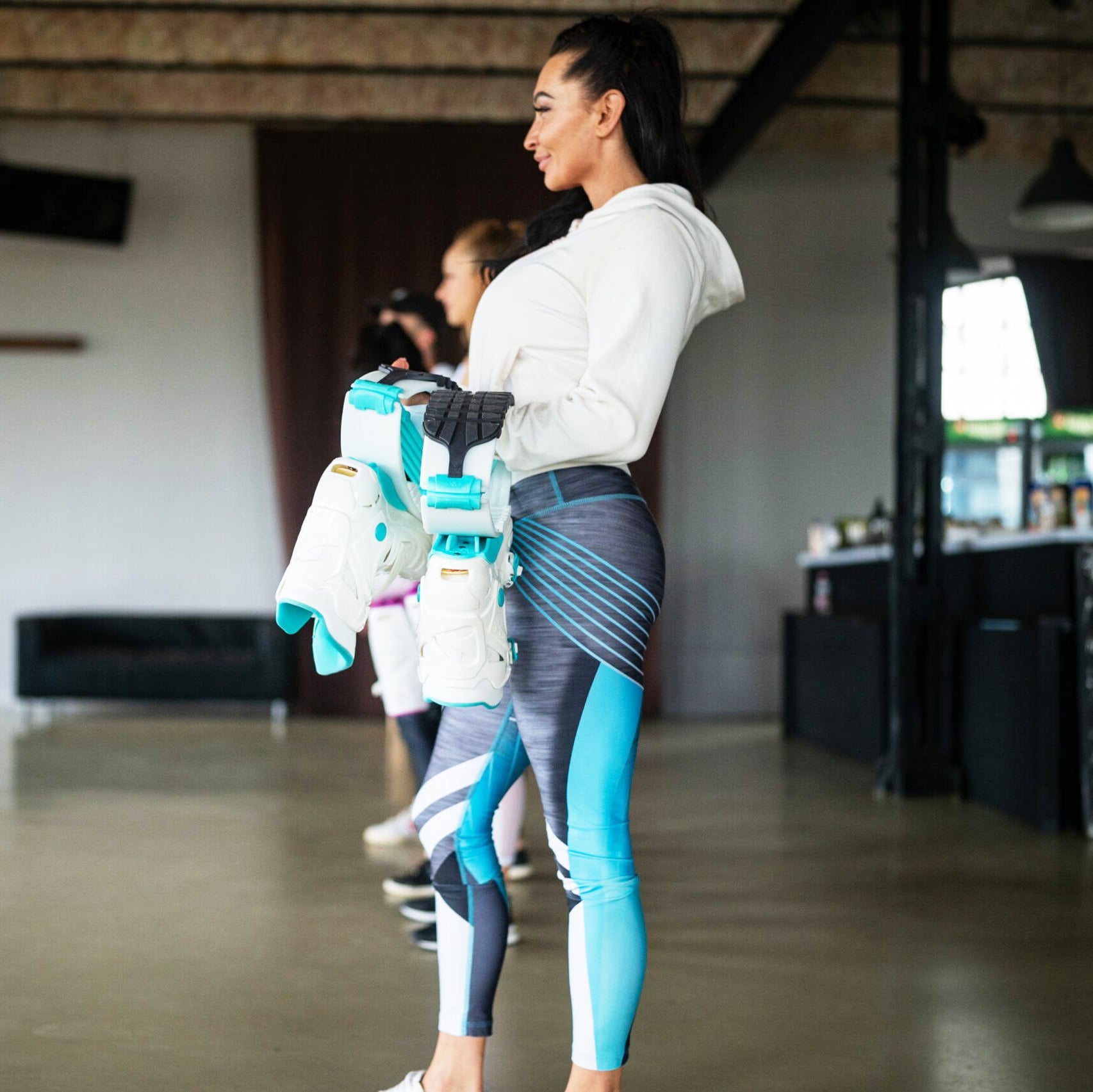 Woman in athletic wear standing in a room with blurred background