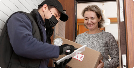 Person delivering a package to a woman at her door.