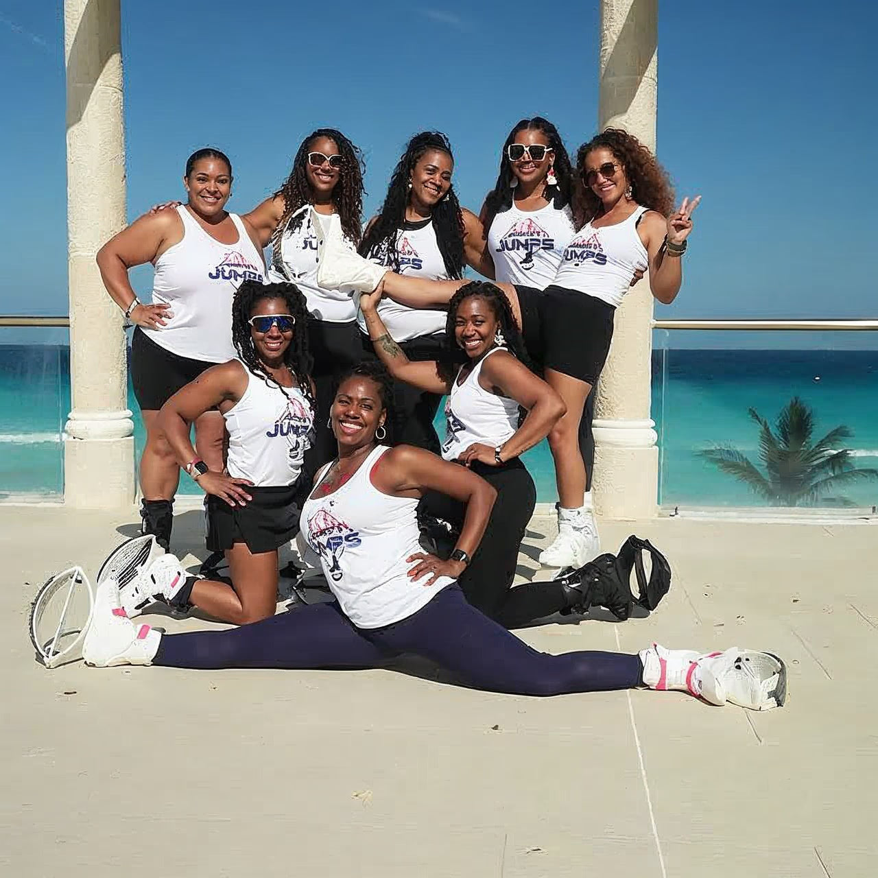 Group of women posing on a balcony with ocean view