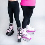 Two people standing side by side wearing Fit Boots Rebound Boots in pink