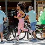 Woman running on a street while wearing pink Fit Boots Rebound Boots